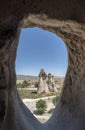 typical fairy chimney view from inside an dug out cave, geological formation of eroded rock, in the open air museum of Goreme, in Royalty Free Stock Photo