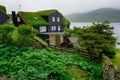 Typical Faroese village with traditional grass roof house and stunning fjord landscape on horizon. Bour Village. Vagar Island, Royalty Free Stock Photo