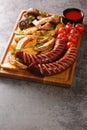 Typical fast food Grilled sausages with potato wedges and mushrooms and sauce close-up on a wooden tray. vertical Royalty Free Stock Photo