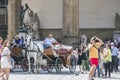 Typical florentine horse buggy stop waiting for tourists in front of the building called Logia dei Lanzi in the square