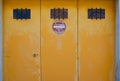 vintage car garage in france with no parking sign (defense de stationner). weathered yellow car garage door.