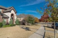 Typical front porch entrance of new suburban houses with parked car on colorful fall street outside Dallas, Texas, USA