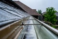 Selective focus on a section of residential guttering with hanger conveying water during a storm. Rain splatters and Royalty Free Stock Photo