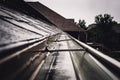 Selective focus on a section of residential guttering with hanger conveying water during a storm. Rain splatters and Royalty Free Stock Photo