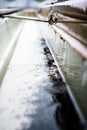 Selective focus on a section of residential guttering with hanger conveying water during a storm. Rain splatters and Royalty Free Stock Photo