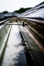Selective focus on a section of residential guttering with hanger conveying water during a storm. Rain splatters and Royalty Free Stock Photo
