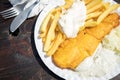 Typical German Friesland deep fried Pollack fish in beer batter with French fries, mayonnaise, sauce tartar and coleslaw on wooden Royalty Free Stock Photo