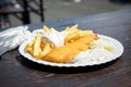 Typical German Friesland deep fried Pollack fish in beer batter with French fries, mayonnaise, sauce tartar and coleslaw on wooden Royalty Free Stock Photo