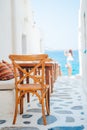 Benches with pillows in a typical greek outdoor cafe in Mykonos with amazing sea view on Cyclades islands Royalty Free Stock Photo