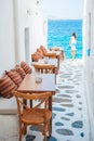 Benches with pillows in a typical greek outdoor cafe in Mykonos with amazing sea view on Cyclades islands Royalty Free Stock Photo