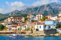 Typical Greek fishing boat in Kokkari bay with town houses in background, Samos island, Greece Royalty Free Stock Photo