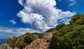 Typical Greek landscape, hill, mountain, spring foliage, bush, olive tree, rocky path. Blue sky with beautiful clouds Royalty Free Stock Photo