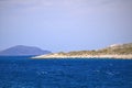 Small greek island on Mediterranean Sea, deep blue water, rocky islet with scant vegetation and some building. Islands near Crete. Royalty Free Stock Photo