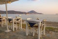 Typical Greek seaside tavern table with wooden chairs by the sea coast in Gialova near Pylos city, Messinia, Greece