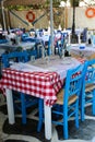 Typical Greek tavern with blue chairs and tables with chequered Royalty Free Stock Photo