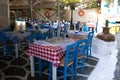 Typical Greek tavern with blue chairs and tables with chequered Royalty Free Stock Photo