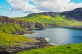 Typical green meadows and seaside of Isle of Skye, Scotland, on a sunny beautiful day of summer. Bright green and blue