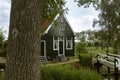 Typical green wooden house of the village Zaanse Schans in Netherlands. Trees, nature and a small bridge. Beautiful landscape.