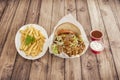 Typical grilled lamb kebab meat sandwich on a skewer served as a menu with French fries and tomato sauces and yogurt in a European