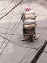 Typical Hanoi; Man with heavy load on scooter drives through Han