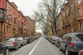 Typical Harlem Neighborhood With Brown Detached Houses, Bare Trees and Vehicles Parked Across the Road. Urban Street Photography