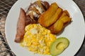 Typical Honduran breakfast of scrambled eggs, fried plantain, avocado, refried beans, tortilla chips and ham Royalty Free Stock Photo