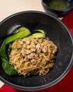 Typical Hong Kong yamin noodles topped with chicken and served with vegetables