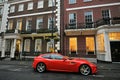 Typical house in Mayfair London with a red Ferrari vintage car