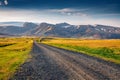 Typical icelandic landscape of empty country road with volcanic mountains on background. Royalty Free Stock Photo