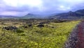 Lava Iceland rocks panorama with red road and old volcano mount at horizon Royalty Free Stock Photo