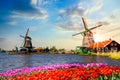 Typical iconic landscape with beautiful sunset in the Netherlands, Europe. Traditional old dutch windmills with house near river Royalty Free Stock Photo