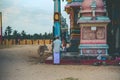 Typical Indian village scene of a calf and people near a colorful temple