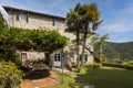Typical Italian farmhouse of Tuscany. Exterior with large garden stone walls and palm trees
