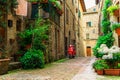 Typical Italian street with colorful flowers and scooter, Pienza, Tuscany