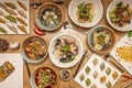 Typical Japanese food recipes with various types of ramen, fried gyozas, cooked gyozas and wooden chopsticks on panda bears