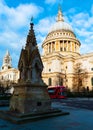 Typical London scene of St Paul`s Cathedral and an iconic red double decker bus in a bright sunny day Royalty Free Stock Photo