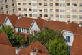 Typical and lovely houses surrounded by ugly and oppressive flat building, green lung in city