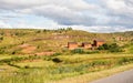 Typical Madagascar landscape - green and yellow rice terrace fields on small hills with clay houses in region near Royalty Free Stock Photo