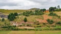 Typical Madagascar landscape - green and yellow rice terrace fields on small hills with clay houses in region near Farariana Royalty Free Stock Photo