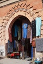 Typical market stall selling a range of clothes to tourists with arch gate in Marrakech, Morroco