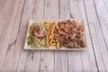 Typical menu tray of a kebab restaurant with mixed meat of chicken and lamb, french fries and salad with tomato and onion Royalty Free Stock Photo