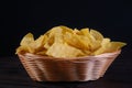 Typical mexican cuisine corn nachos, inside wicker bowl, rush isolated on black background Royalty Free Stock Photo