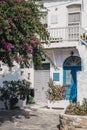 Typical Mykonian white house with blue front door pink blossoming tree in front, Mykonos, Greece Royalty Free Stock Photo