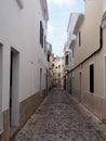 Typical narrow long empty cobbled street of traditional painted houses in ciutadella menorca