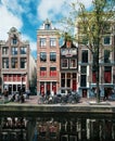 Typical narrow houses with large windows and canals with reflection, Amsterdam, Netherlands.