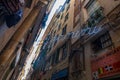 Typical narrow street of Genoa with cafe, shops and multi-colored facades of buildings, Liguria region, Italy Royalty Free Stock Photo