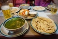 Typical nepalese meal and beer in Pokhara restaurant, Himalayas, Nepal. Assorted indian nepalese food on table. Dishes and appetiz