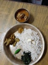 A typical nepali plate or thali in chures ko thal. Here it includes a bowl of meat , veg, a chilli and two cloves of garlic.
