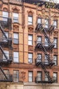 Typical New York City building with fire escape ladders Royalty Free Stock Photo