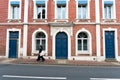 Typical Norman stone and brick house front with colorful contrasts and an Asian woman walking past